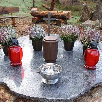 Grabstein mit Kerzen am Urnenfriedhof Zirbitzruh in Waldstück Zirbitzkogel